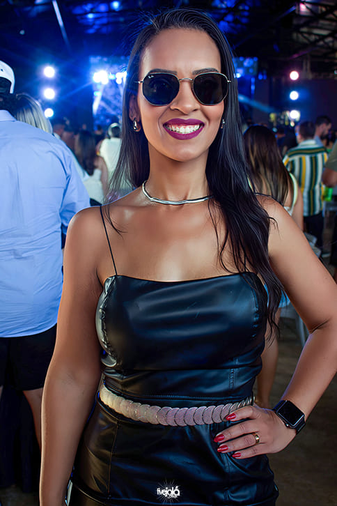 uma mulher morena cabelos pretos sorrindo com ocúlos escuros 
