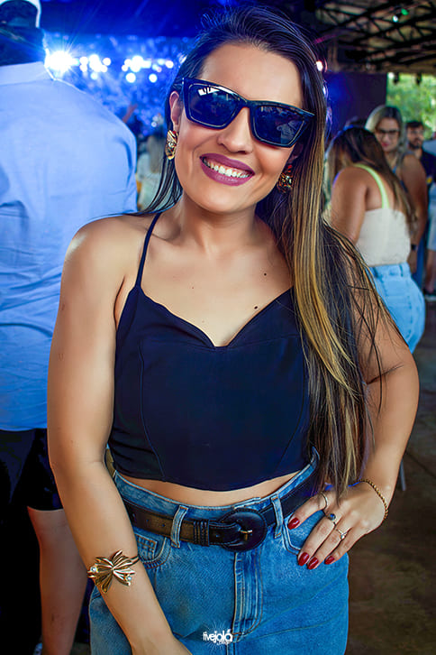  uma mulher de cabelos castanhos claros, com ocúlos escuros sorrindo